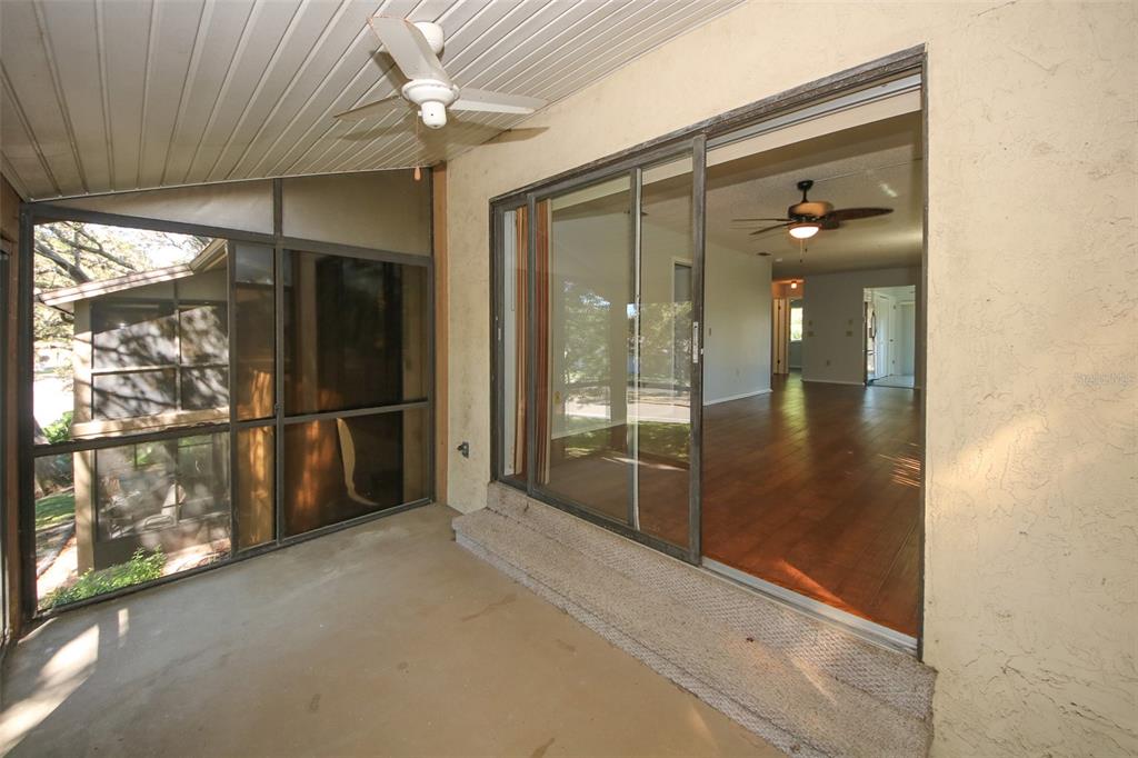 13009 Wedgewood Way, Unit C Hudson, FL 34667 - Photo 20 of 25 a empty room with sliding door and a chandelier fan