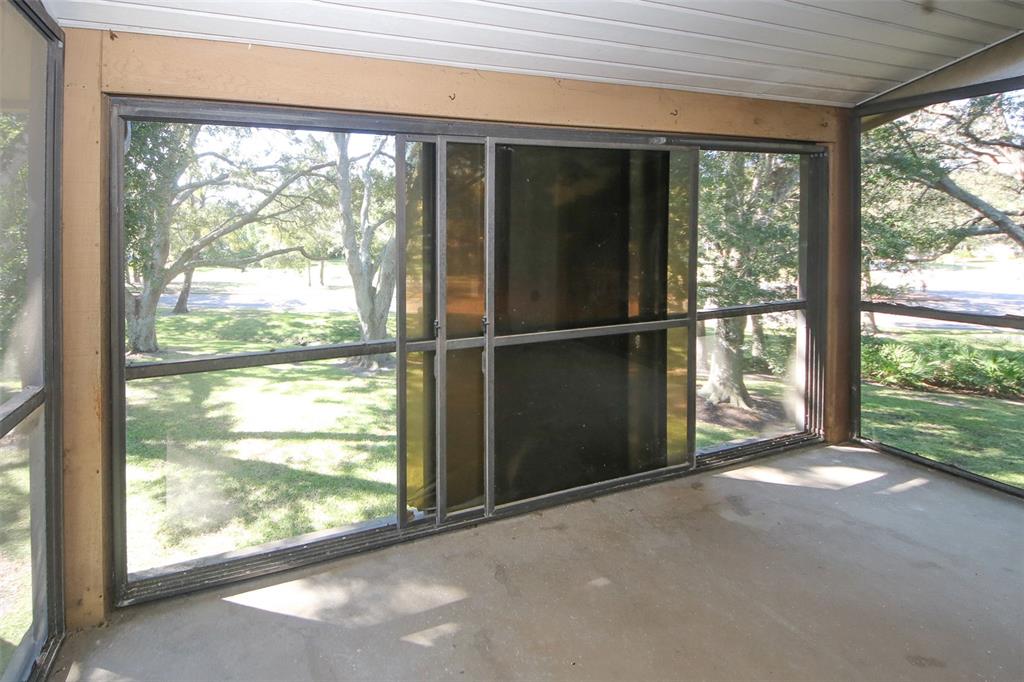 13009 Wedgewood Way, Unit C Hudson, FL 34667 - Photo 22 of 25 a view of an empty room with wooden floor and a large window