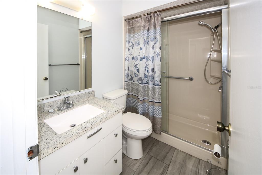 13009 Wedgewood Way, Unit C Hudson, FL 34667 - Photo 7 of 25 a bathroom with a granite countertop sink toilet and shower