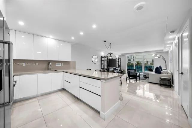 a kitchen with stainless steel appliances a table chairs in it and wooden floors