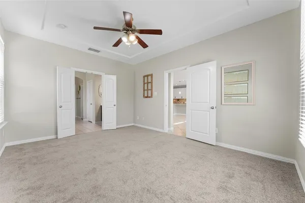 a view of a livingroom with a ceiling fan & entryway