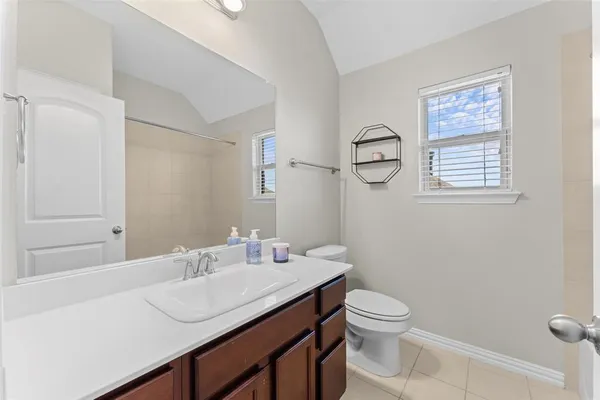 a bathroom with a granite countertop sink a toilet and a mirror