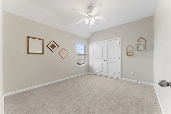 an empty room with windows and fan