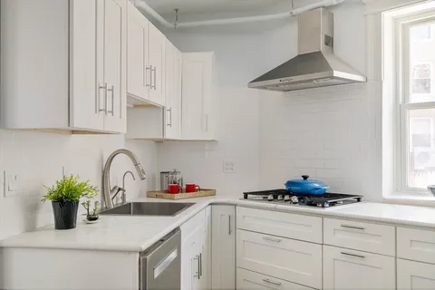 a kitchen with white cabinets and a sink