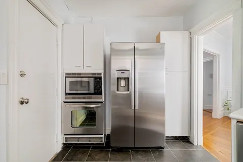 a metallic refrigerator freezer sitting in a kitchen