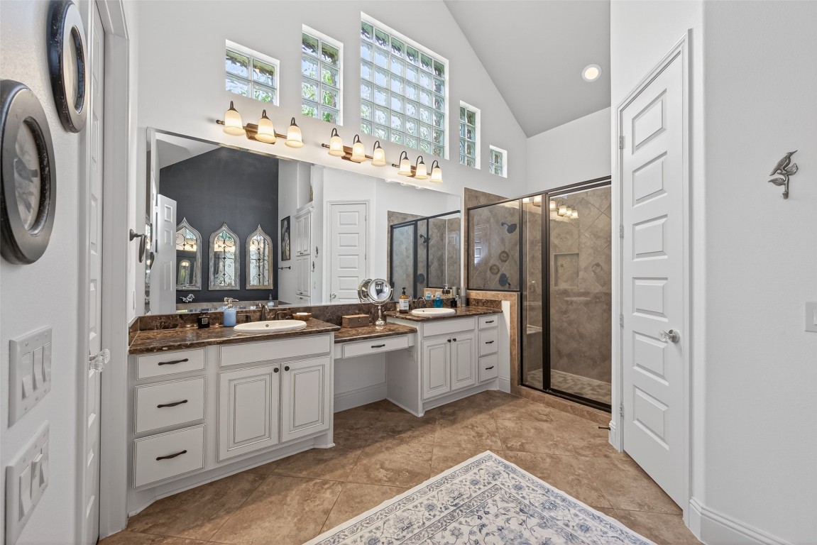 19852 Cullen Ridge Drive Porter, TX 77365 - Photo 18 of 43 This spacious bathroom features high ceilings, abundant natural light through upper windows, dual sinks with granite countertops,make up area, a large walk-in shower with bench, separate soaking tub, and elegant tile flooring.