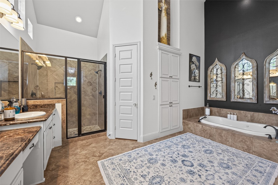 19852 Cullen Ridge Drive Porter, TX 77365 - Photo 19 of 43 This spacious bathroom features high ceilings, abundant natural light through upper windows, dual sinks with granite countertops,make up area, a large walk-in shower with bench, separate soaking tub, and elegant tile flooring.