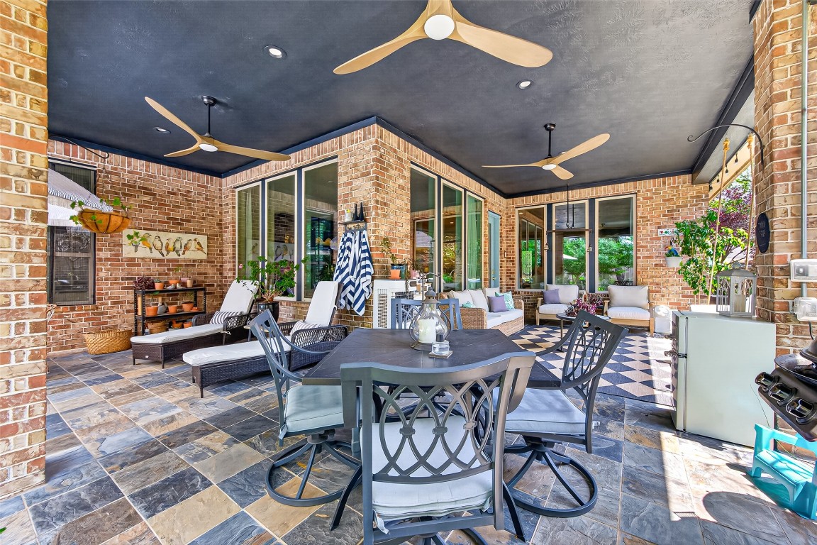 19852 Cullen Ridge Drive Porter, TX 77365 - Photo 27 of 43 This HUGE inviting back patio features elegant brick walls, three ceiling fans for comfort, and comfortable seating areas. The space provides a cozy atmosphere perfect for relaxation or entertaining.