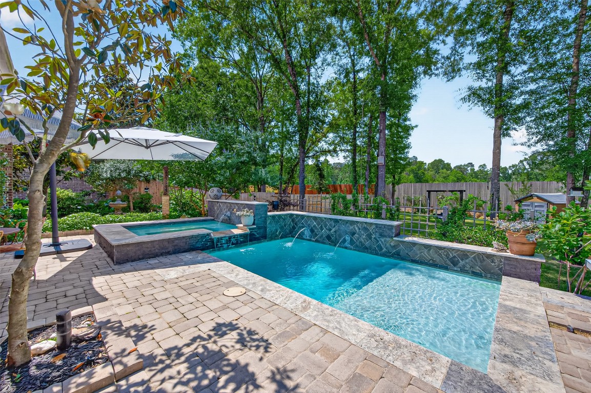 19852 Cullen Ridge Drive Porter, TX 77365 - Photo 29 of 43 True Backyard OASIS features a sparkling pool and Hot Tub with a waterfall feature, a HUGE cozy back patio area and Large back yard with lush greenery and high fences for privacy.