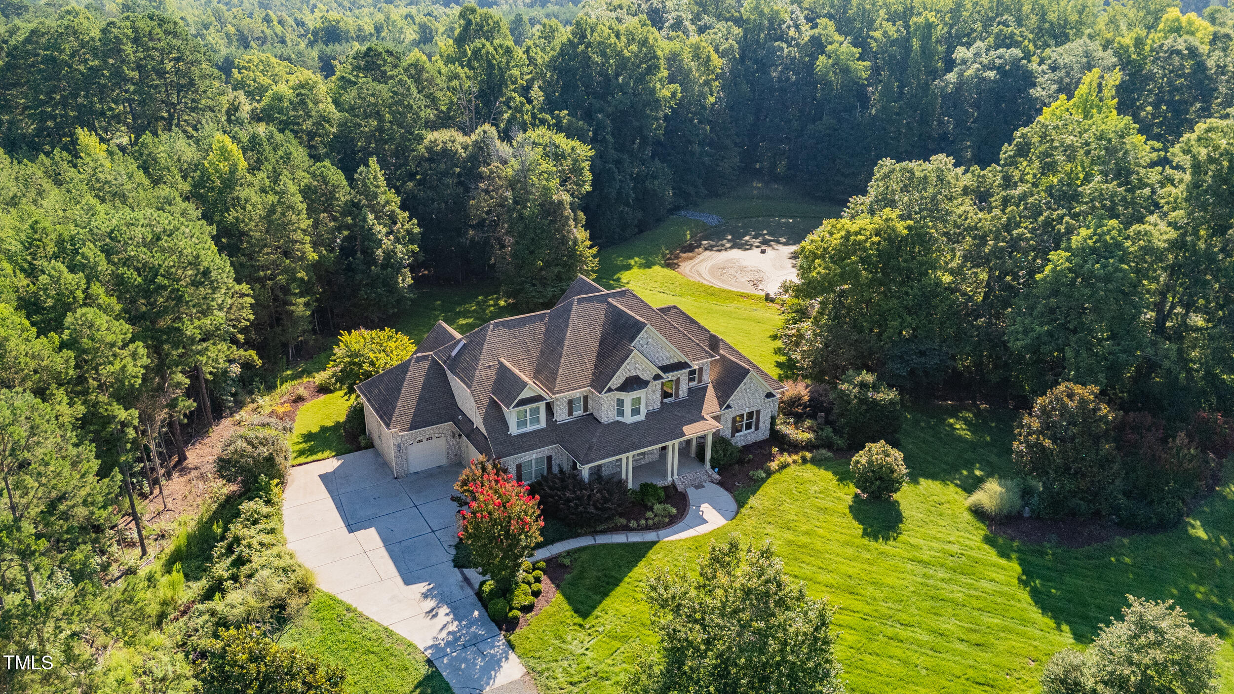 an aerial view of a house with a yard basket ball court and outdoor seating