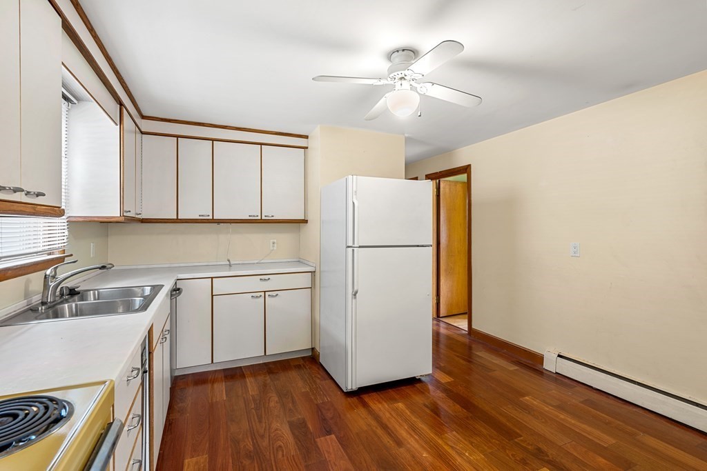 9-13 Sutherland Road Arlington, MA 02476 - Photo 3 of 20 a kitchen with a sink a refrigerator a stove and cabinets