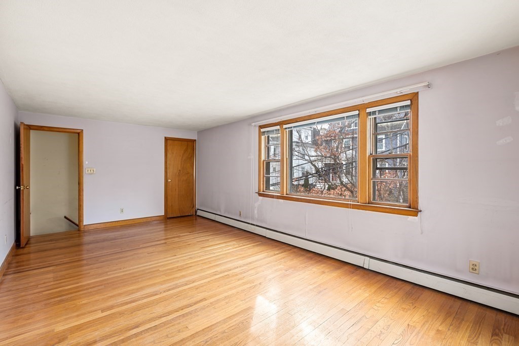 9-13 Sutherland Road Arlington, MA 02476 - Photo 7 of 20 wooden floor in an empty room with a window