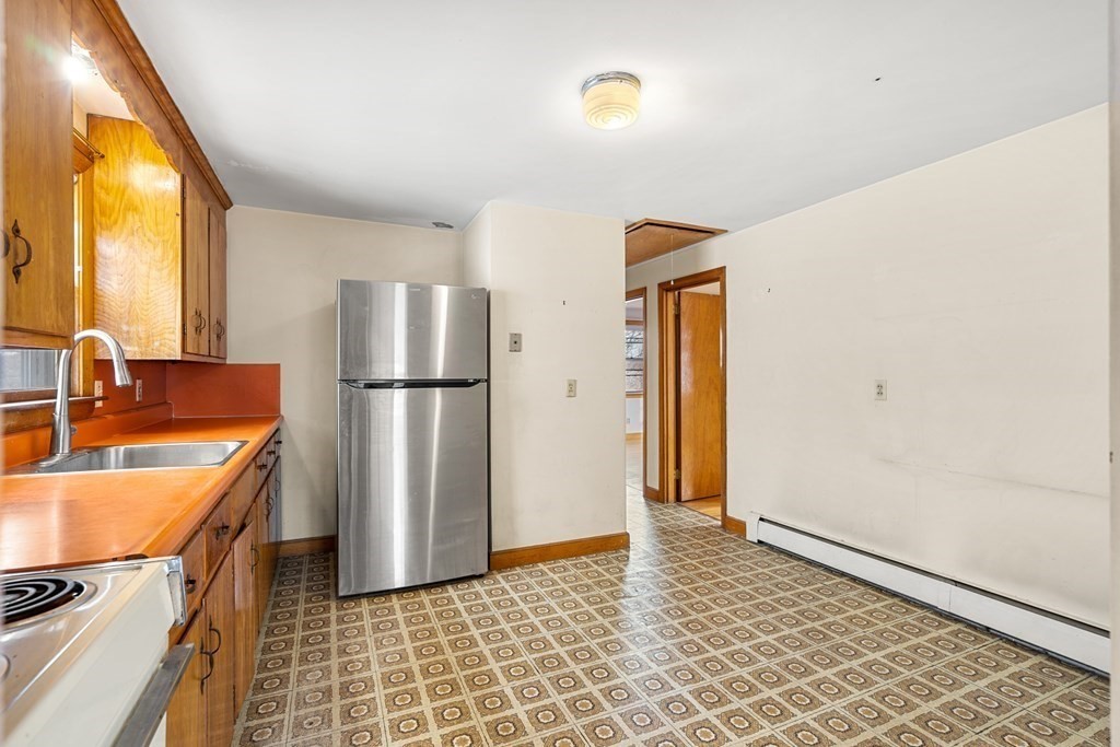 9-13 Sutherland Road Arlington, MA 02476 - Photo 9 of 20 a kitchen with a refrigerator and a sink