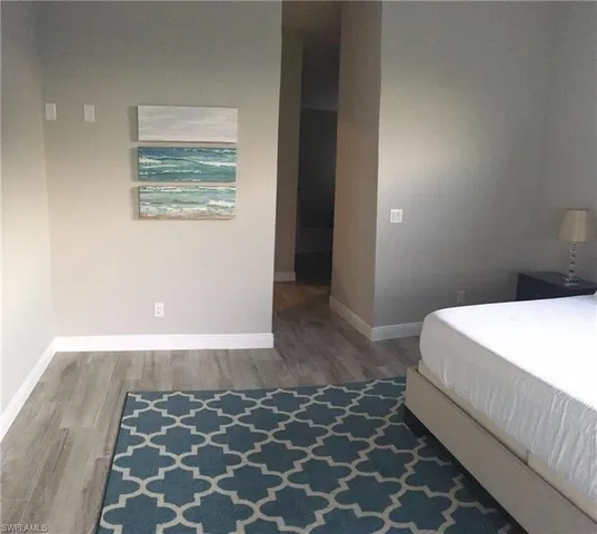 a bedroom with a bed and a black wall painting