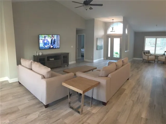 a living room with furniture and a flat screen tv with wooden floor