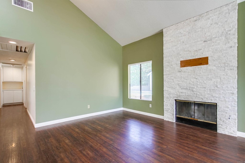 875 Viewpoint Drive San Marcos, CA 92078 - Photo 17 of 60 an empty room with wooden floor fireplace and windows