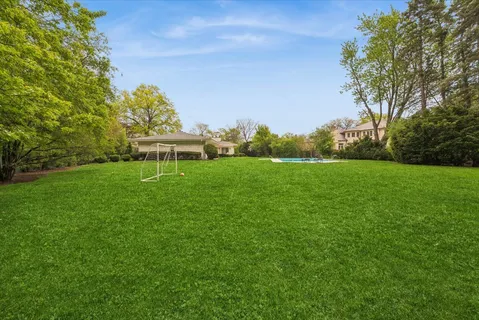 a view of a house with a big yard and a large tree