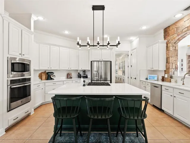 a bedroom with a bed chandelier and dresser