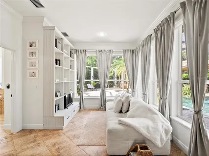 a view of a white house with a yard and palm trees