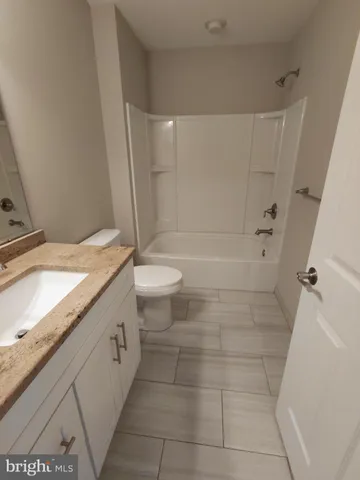 a bathroom with a sink a toilet a mirror and shower