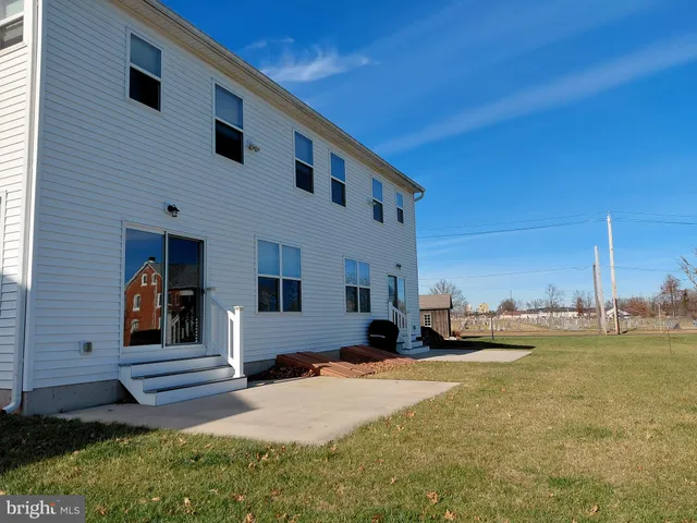 a view of a house with backyard and a tree