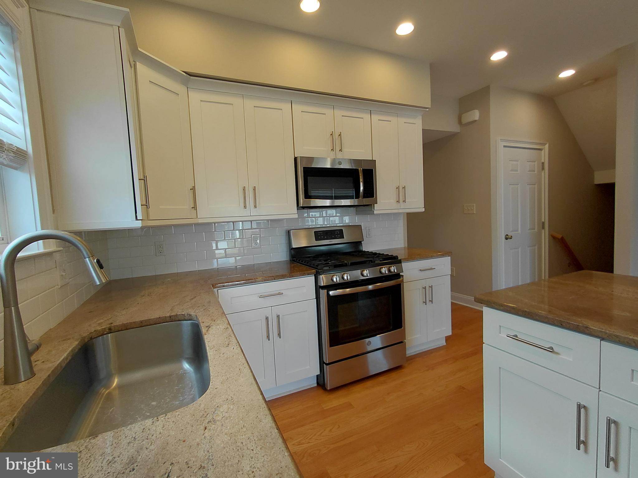912 Cemetery Road Quakertown, PA 18951 - Photo 8 of 16 a kitchen with stainless steel appliances granite countertop a sink a stove a refrigerator and a sink with wooden floor