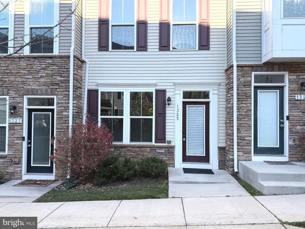 a view of a brick house with a large windows and plants