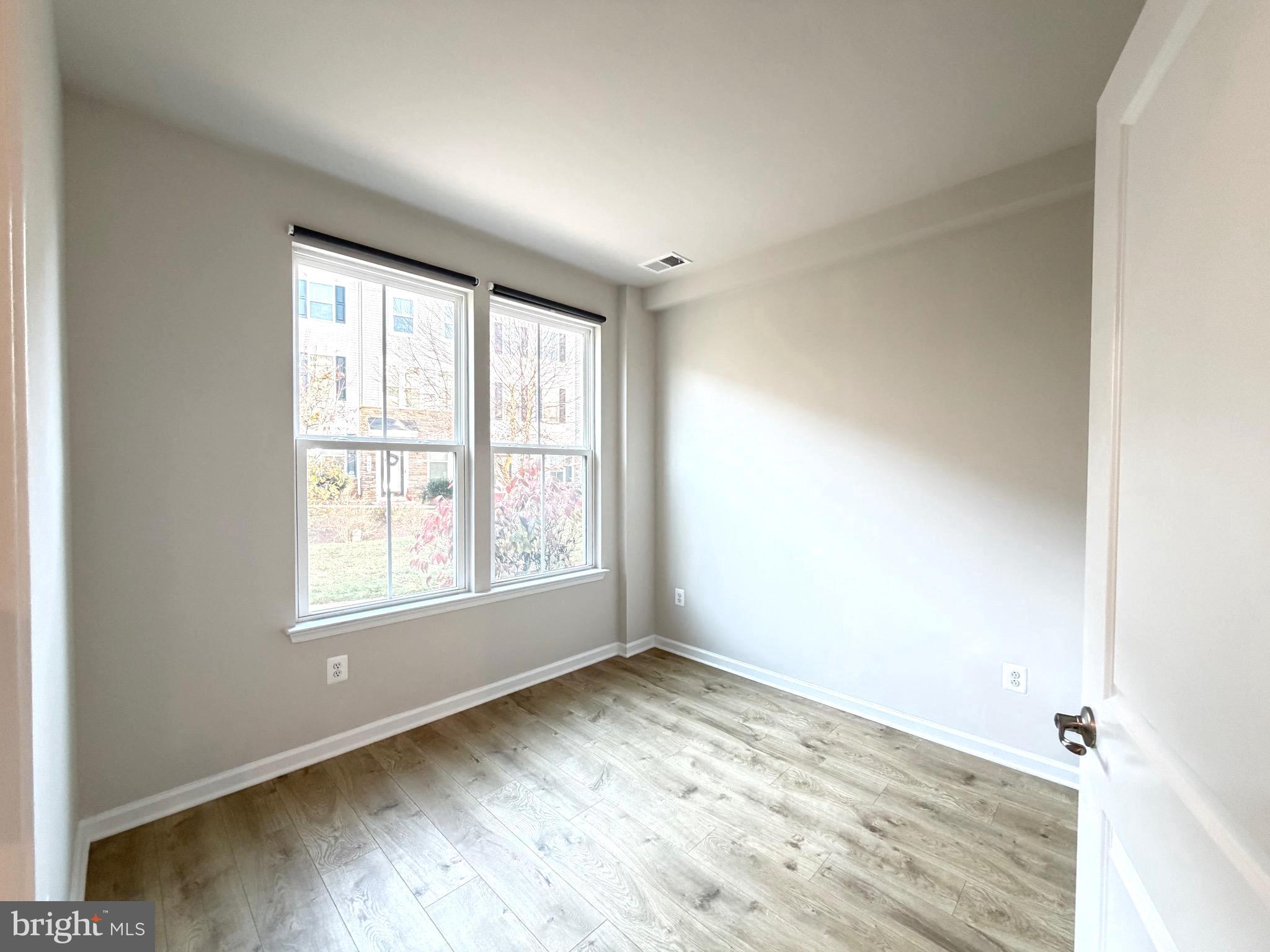 1325 Bruley Road Hanover, MD 21076 - Photo 19 of 22 an empty room with wooden floor and windows