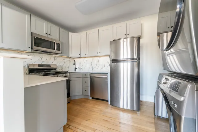 a kitchen with stainless steel appliances granite countertop a refrigerator stove a sink and a microwave