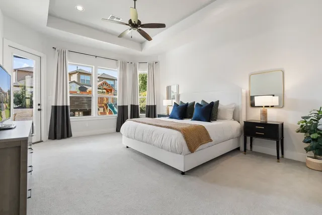 a spacious bedroom with a large bed and a chandelier