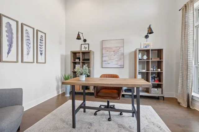 a view of a workspace with furniture and a window