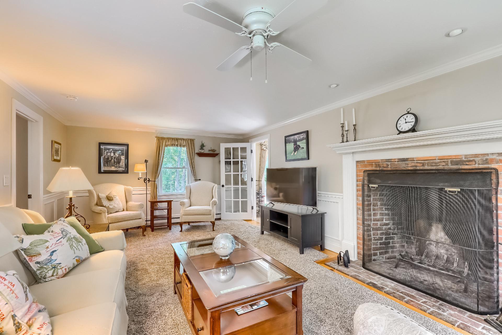 279 Service Road East Sandwich, MA 02537 - Photo 7 of 44 a living room with furniture a fireplace and a flat screen tv