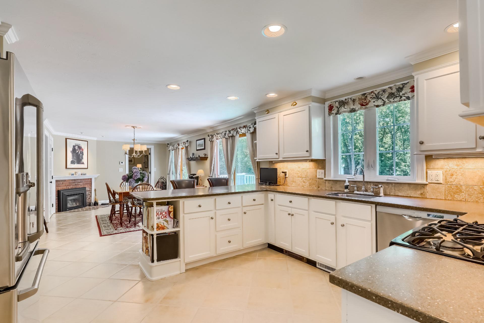 279 Service Road East Sandwich, MA 02537 - Photo 8 of 44 a kitchen with white cabinets and chairs