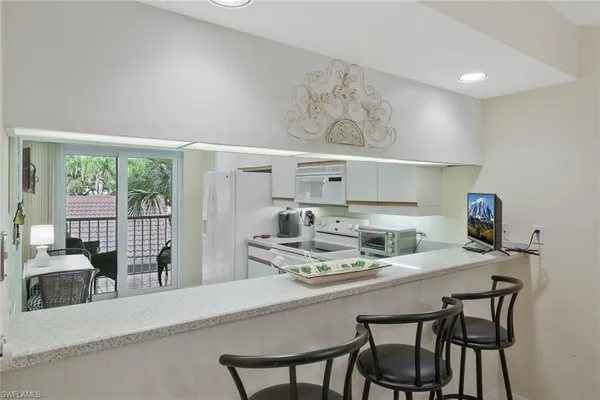 a kitchen with stainless steel appliances a table and chairs in it