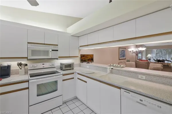 a kitchen with white cabinets and appliances