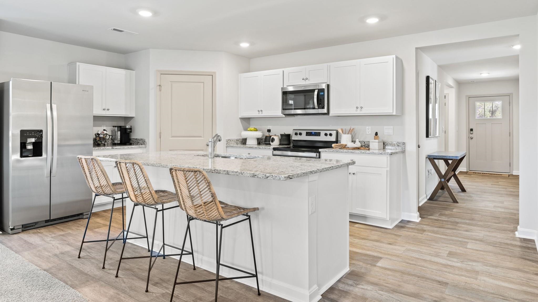 403 Stonewall Jackson Boulevard Staunton, VA 24401 - Photo 23 of 25 a kitchen with stainless steel appliances kitchen island granite countertop a stove a sink a refrigerator with white cabinets and wooden floor