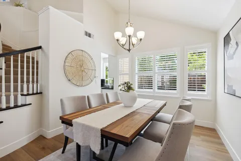 a view of a dining room with furniture a chandelier and wooden floor