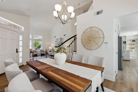 a living room with furniture a mirror and wooden floor