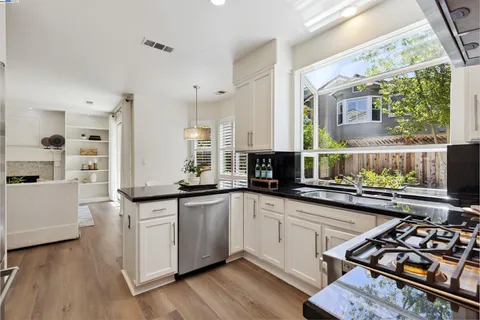 a kitchen with stainless steel appliances a sink a stove and cabinets