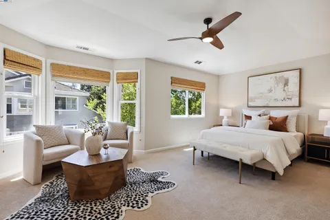 a spacious bedroom with a bed a couch and a large window