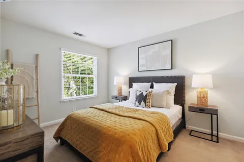 a bed sitting in a bedroom next to a window