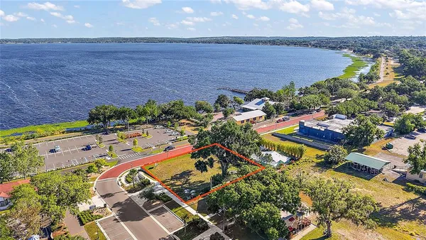 an aerial view of a house with a garden and lake view