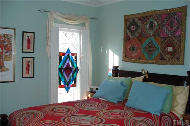 929 Sawmill Road Raleigh, NC 27615 - Photo 7 of 9 a bedroom with a bed and painting on the wall