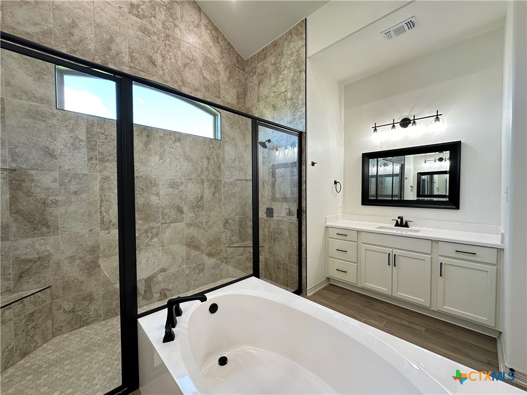 4521 Agave Trail Temple, TX 76502 - Photo 16 of 25 a bathroom with a tub sink a mirror and a shower