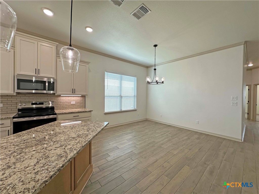 4521 Agave Trail Temple, TX 76502 - Photo 9 of 25 a kitchen with stainless steel appliances granite countertop a sink a stove and a refrigerator