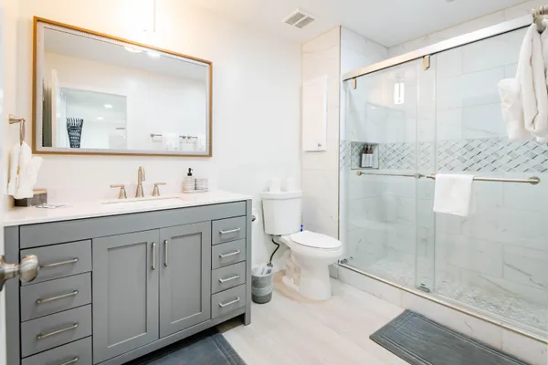 a bathroom with a granite countertop sink toilet and shower