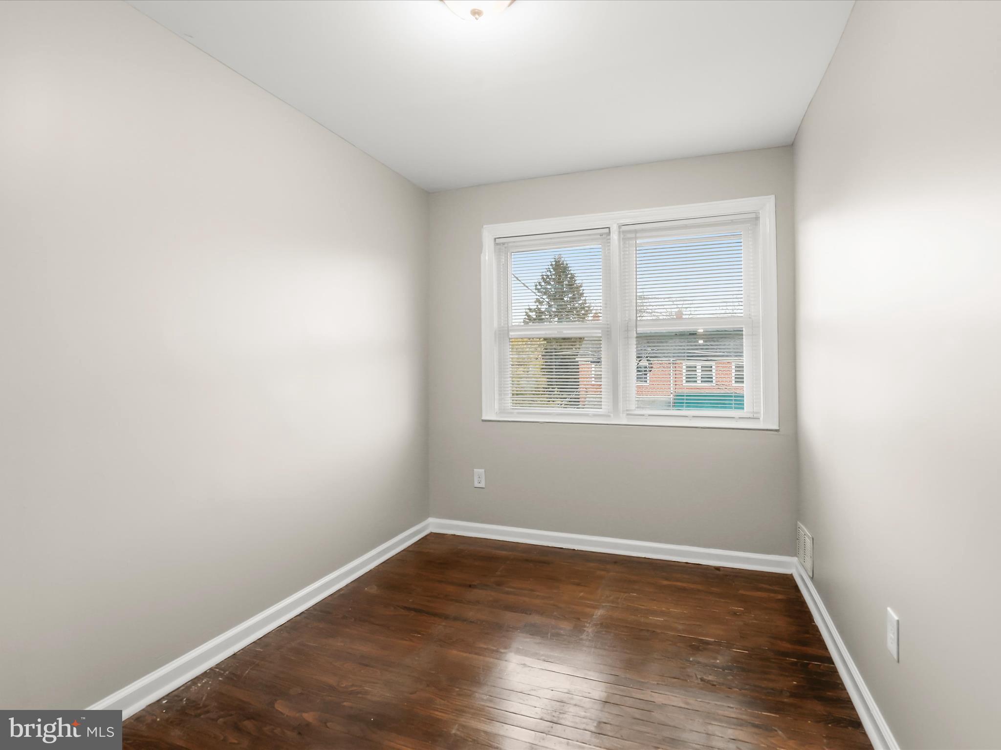 8351 Edgedale Road Baltimore, MD 21234 - Photo 11 of 22 a view of an empty room with wooden floor and a window