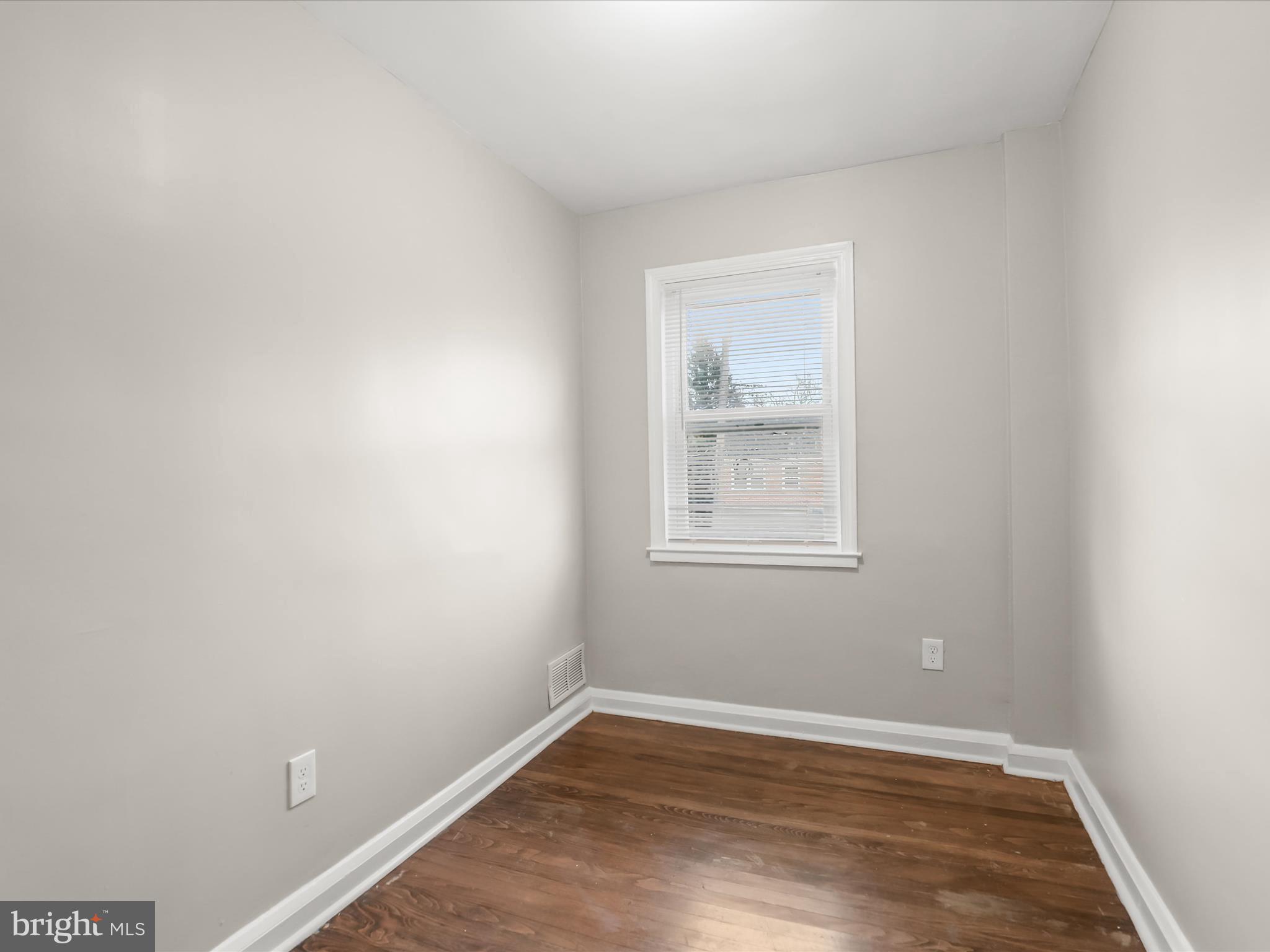 8351 Edgedale Road Baltimore, MD 21234 - Photo 10 of 22 a view of an empty room with wooden floor and a window