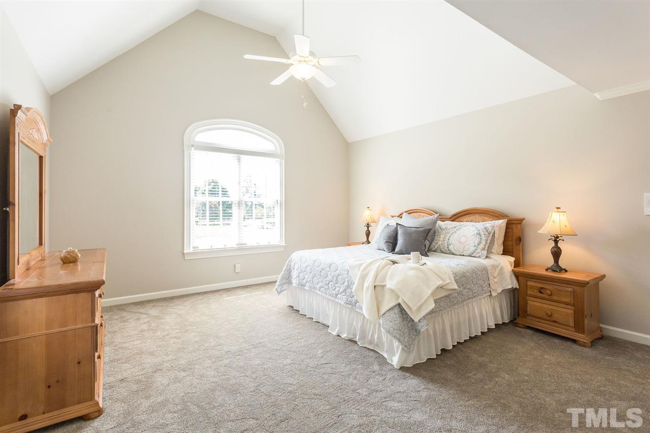 12404 Bayleaf Church Road Raleigh, NC 27614 - Photo 15 of 25 a spacious bedroom with a bed and a flat tv screen on dresser