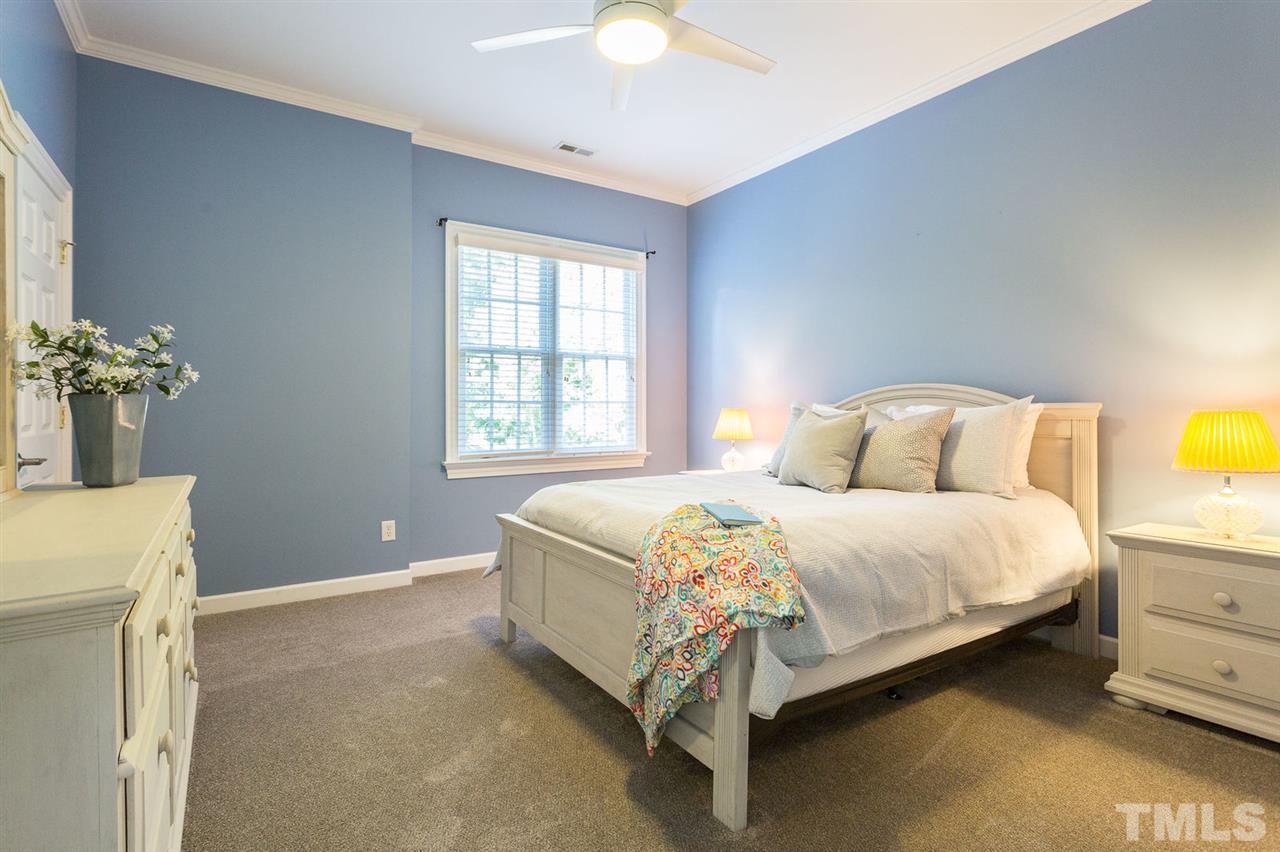 12404 Bayleaf Church Road Raleigh, NC 27614 - Photo 21 of 25 a bedroom with a bed potted plant and a chandelier